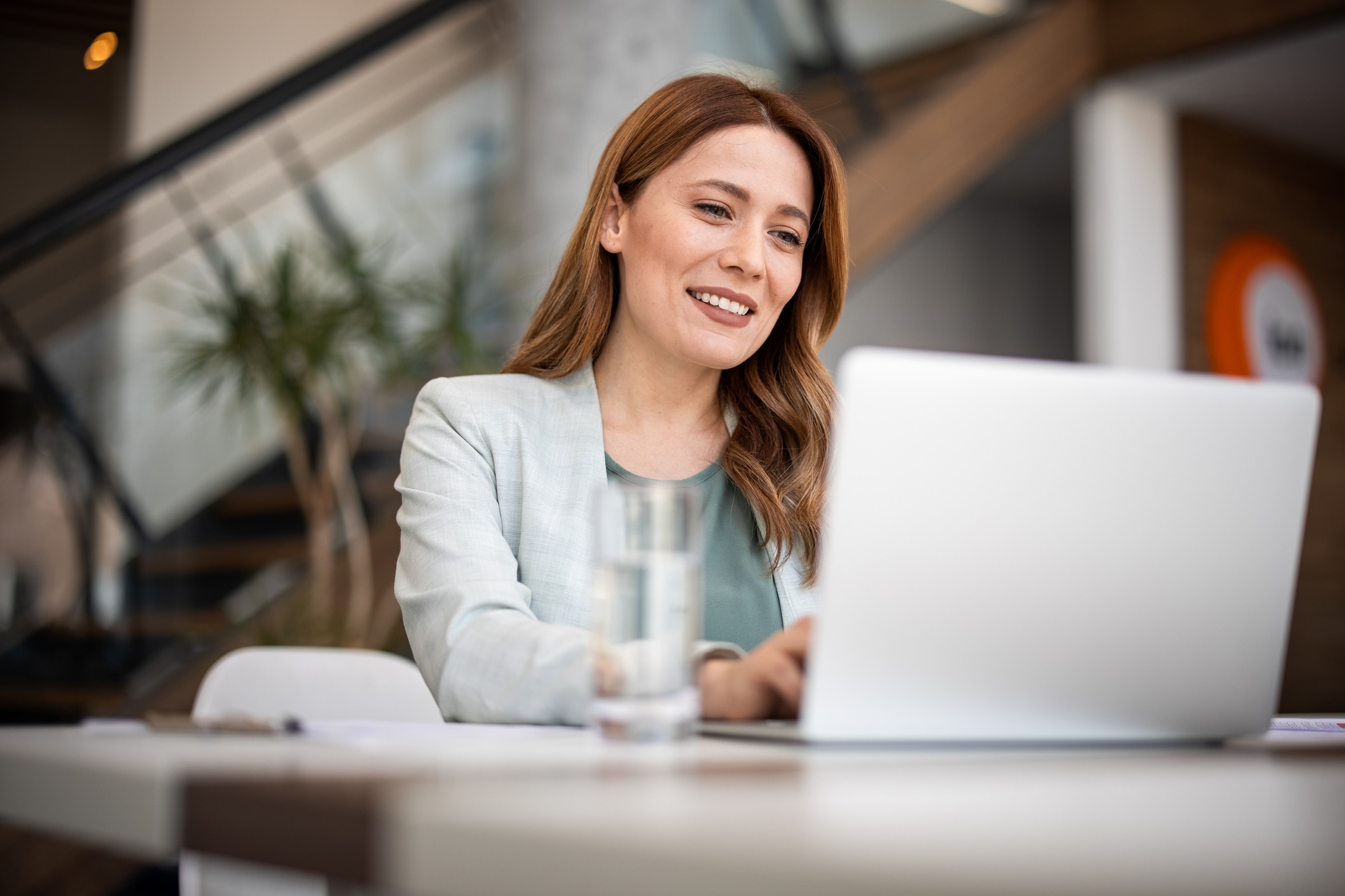 Woman sitting at computer at a desk smiling