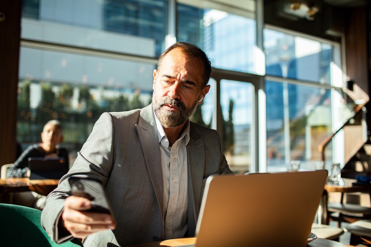 Man on his phone looking at expenses