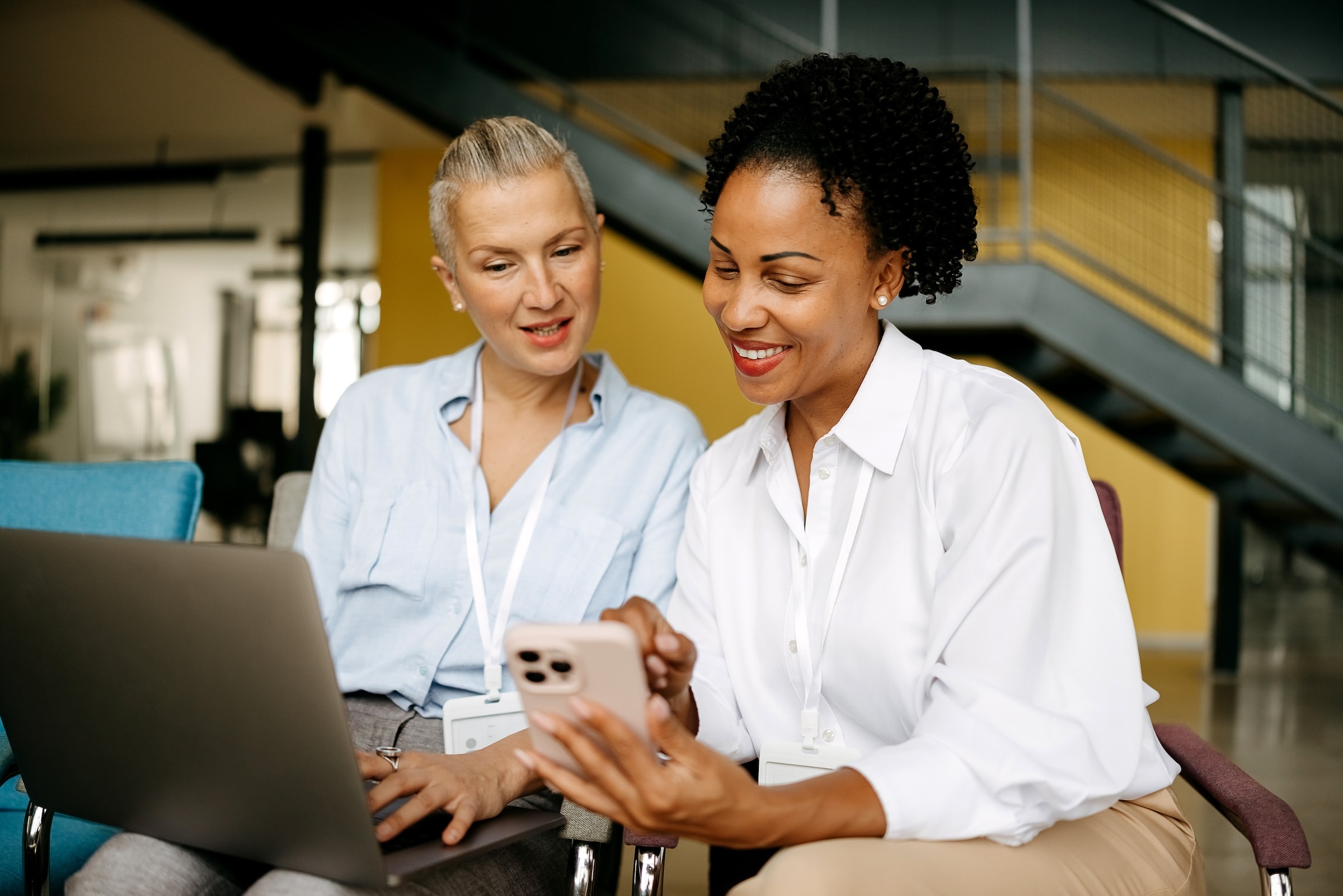 two women looking at a computer in white shirts