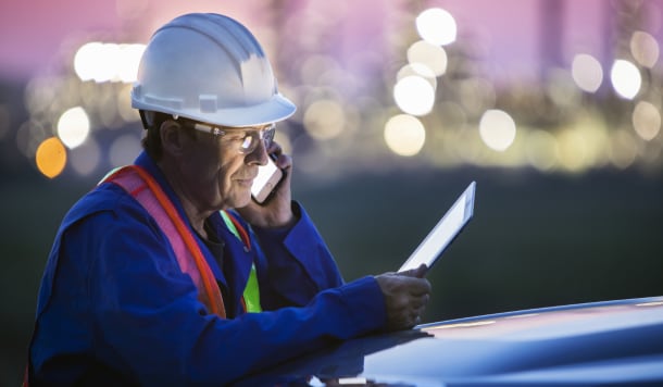 Construction worker uses two mobile devices