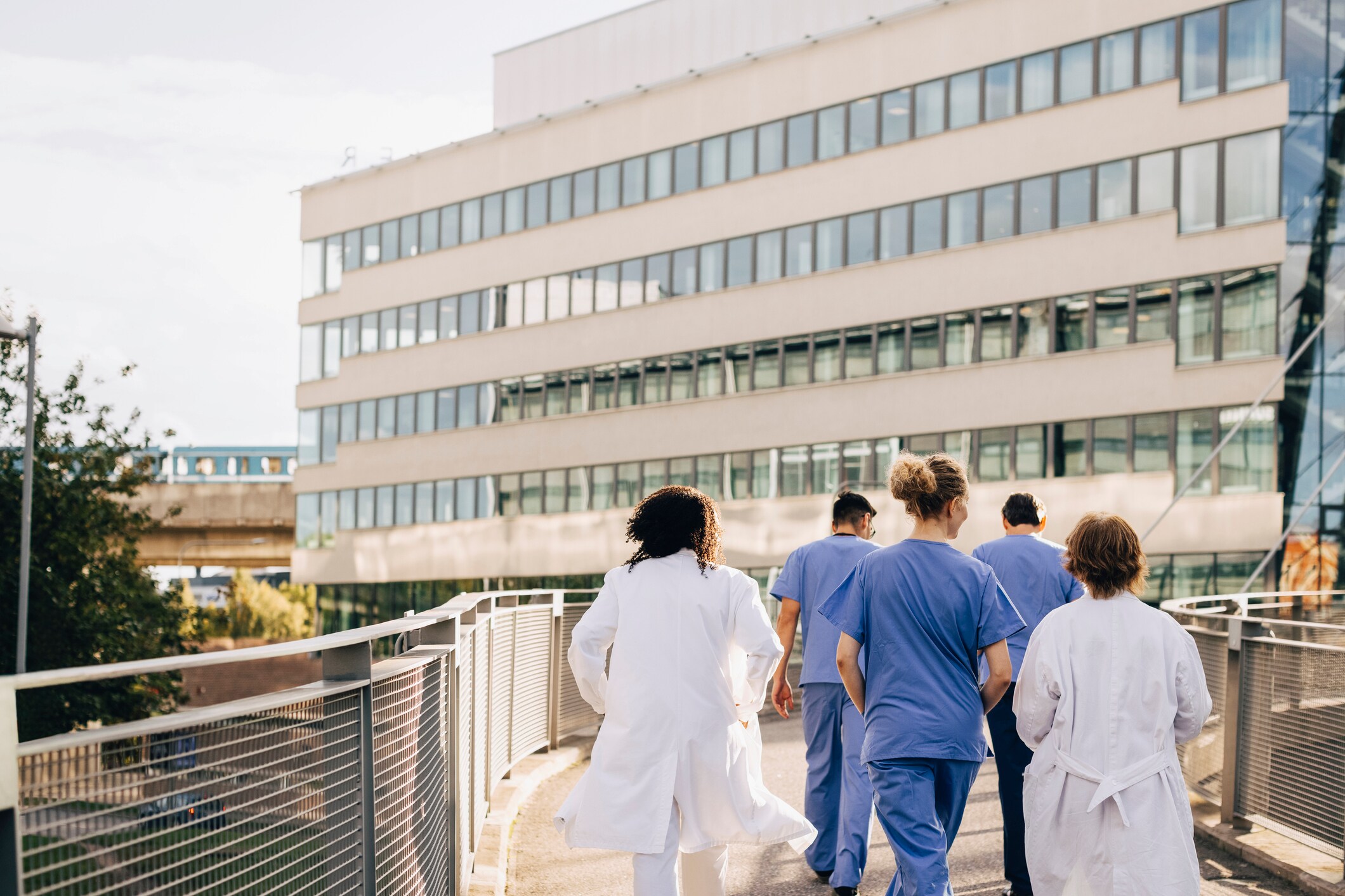 Group of healthcare professionals walking towards a hospital outside