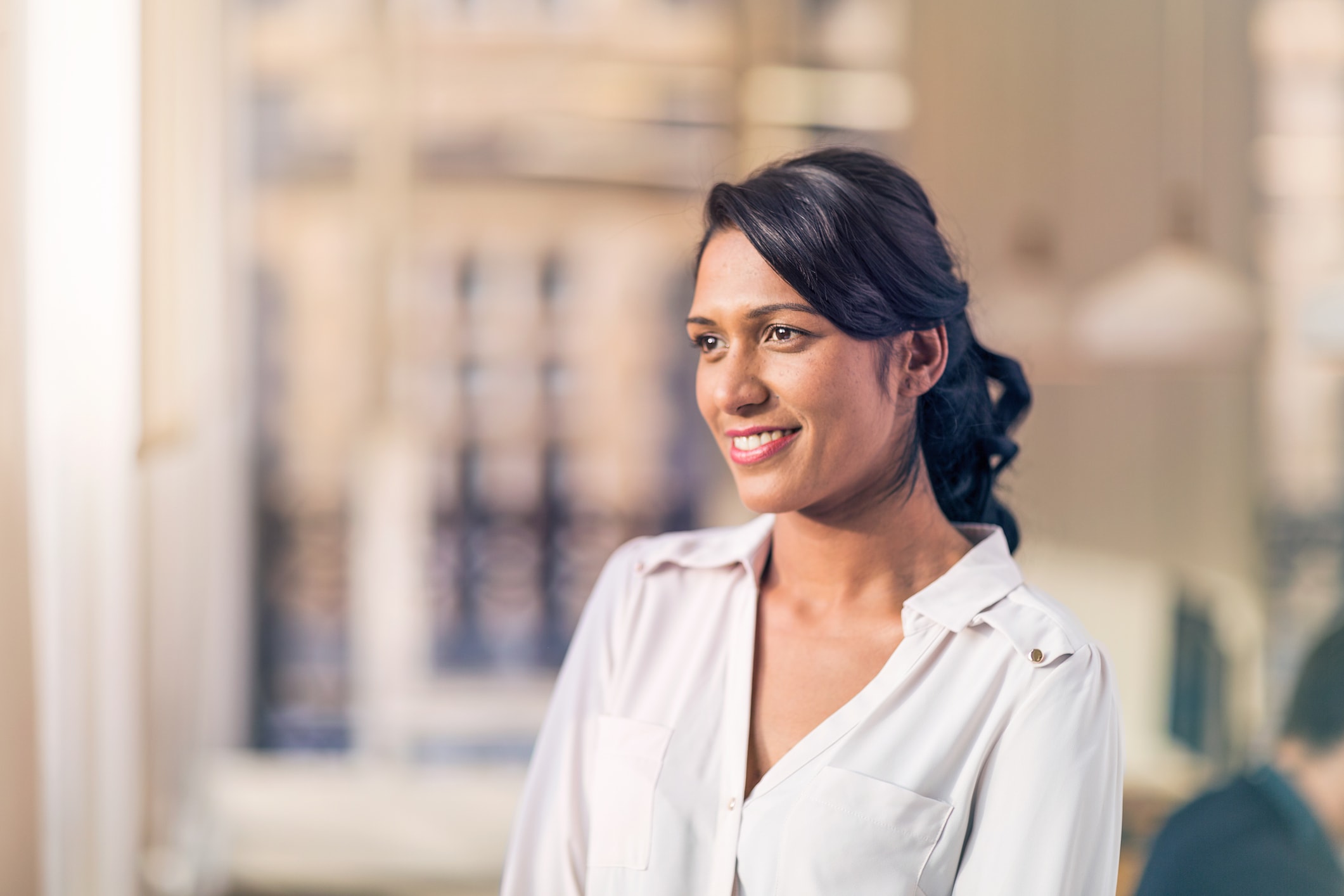 woman, dark hair, white shirt, smiling, in office
