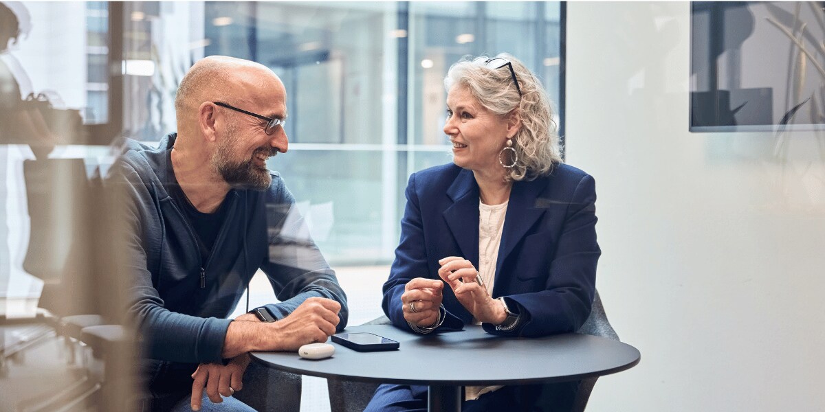 older man and woman talking at table