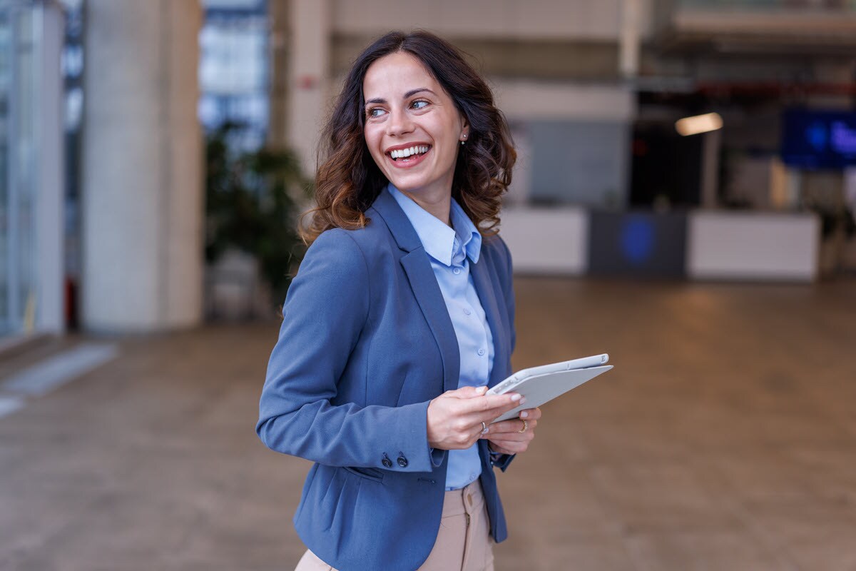 Smiling woman looking away from tablet