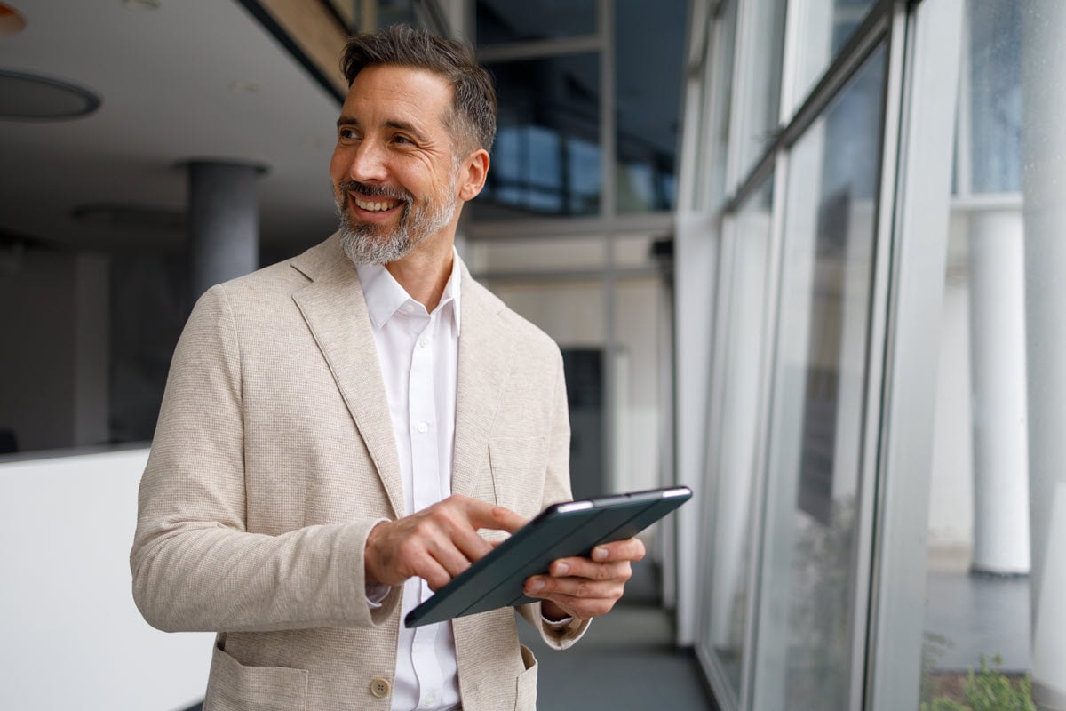 Man in office looking away from tablet