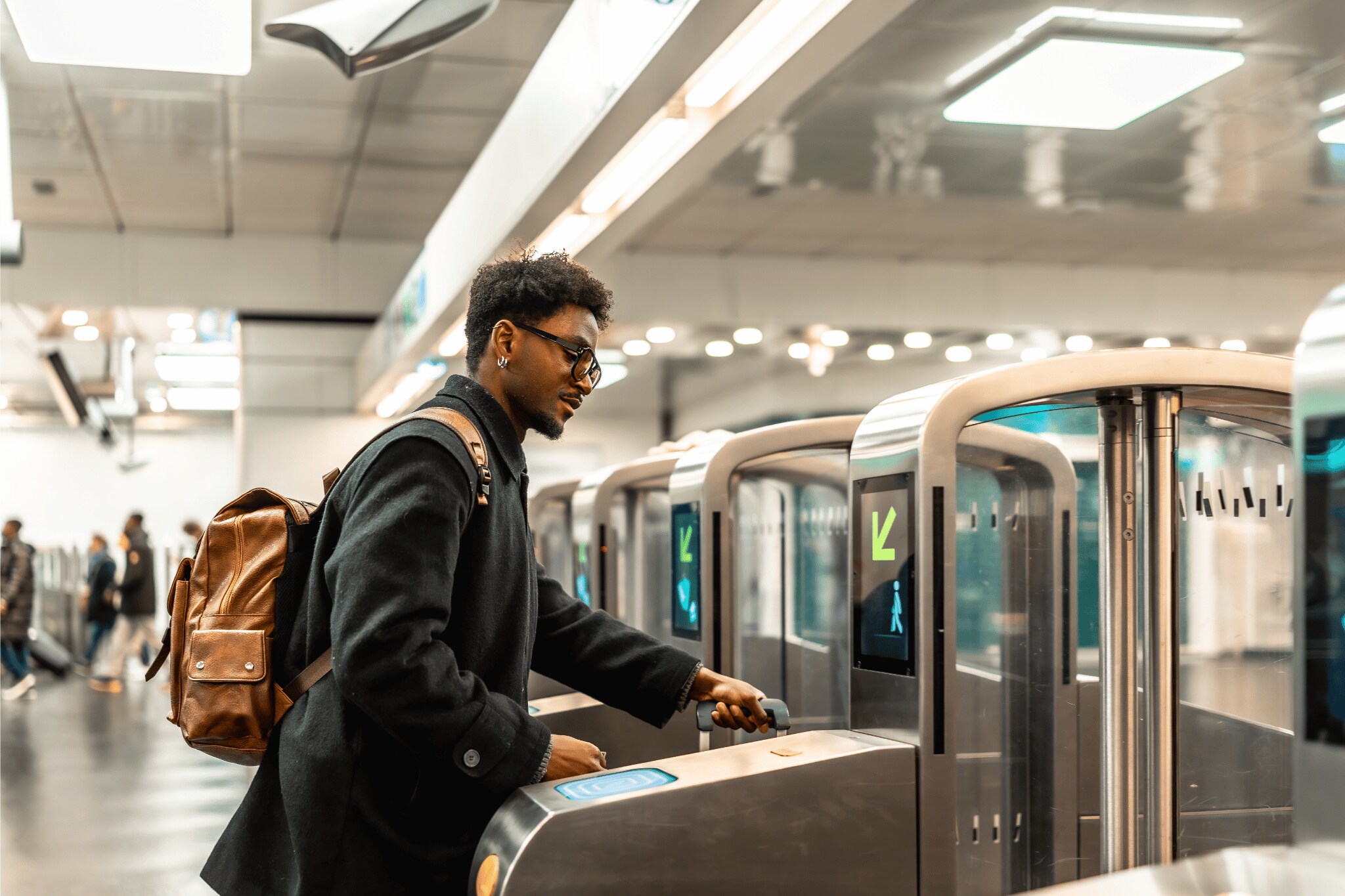 Man with a suitcase passing through a ticket door with a suitcase