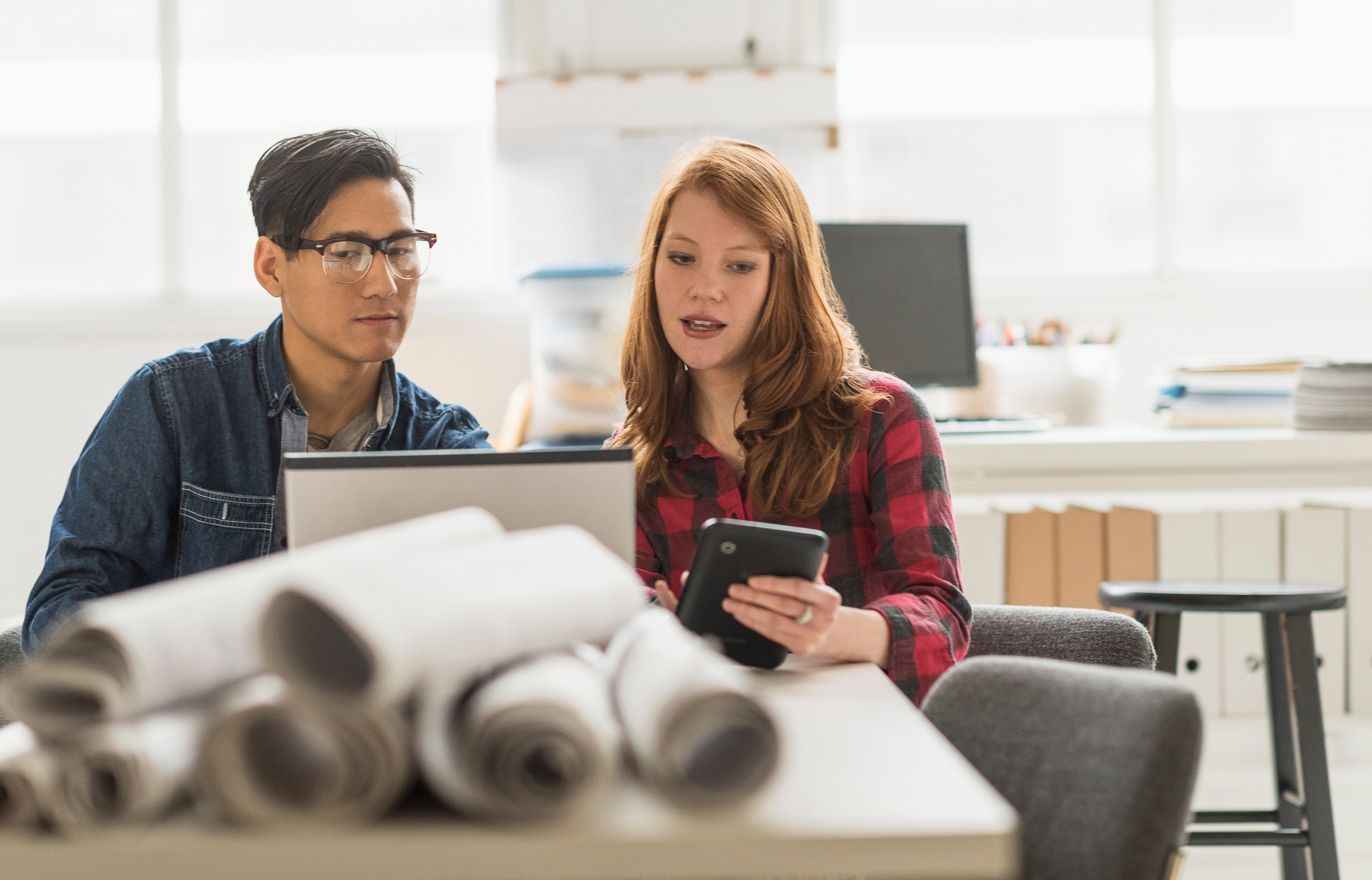 man and woman looking at screens