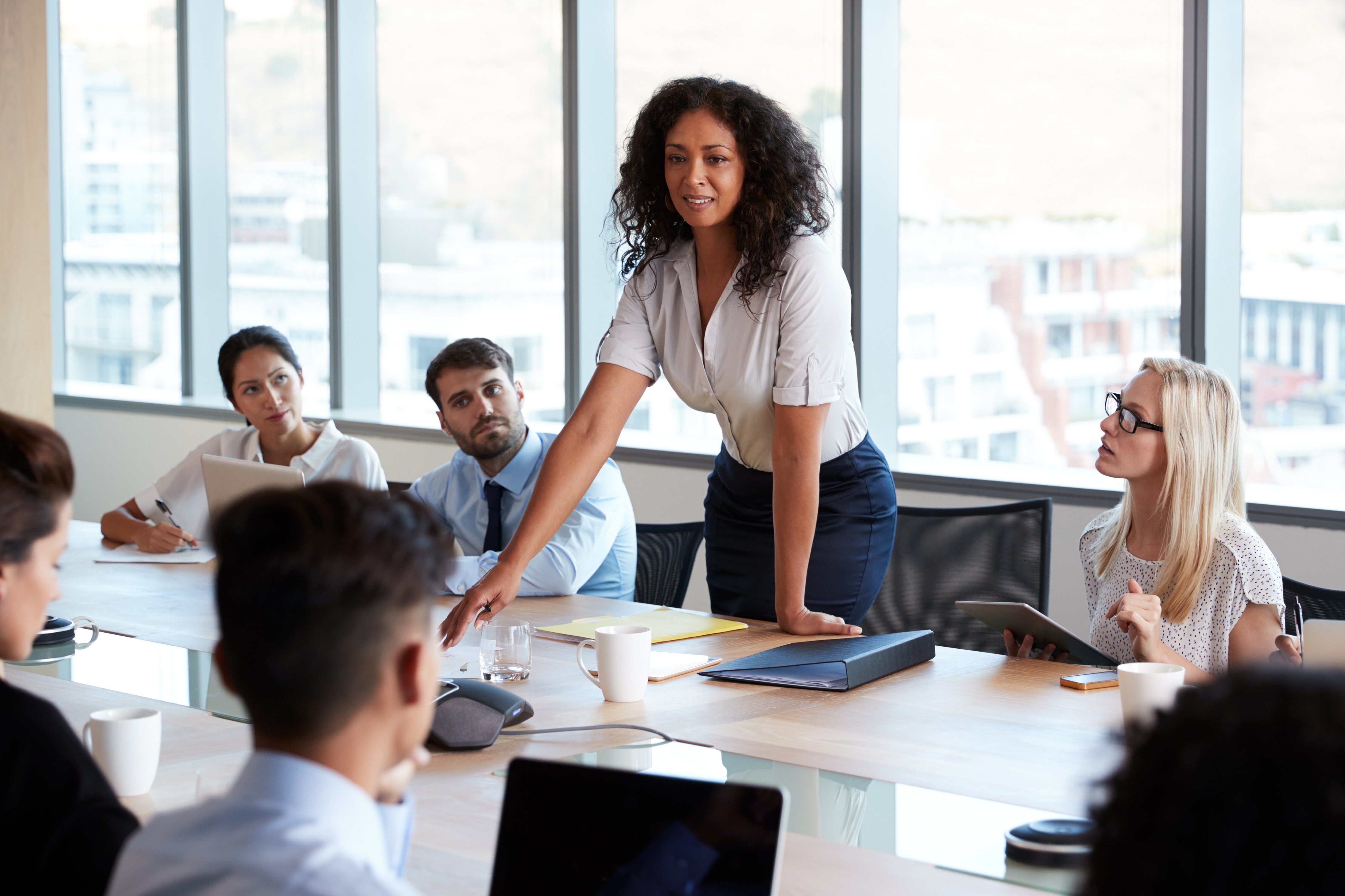 Woman standing in a meeting room with other coworkers