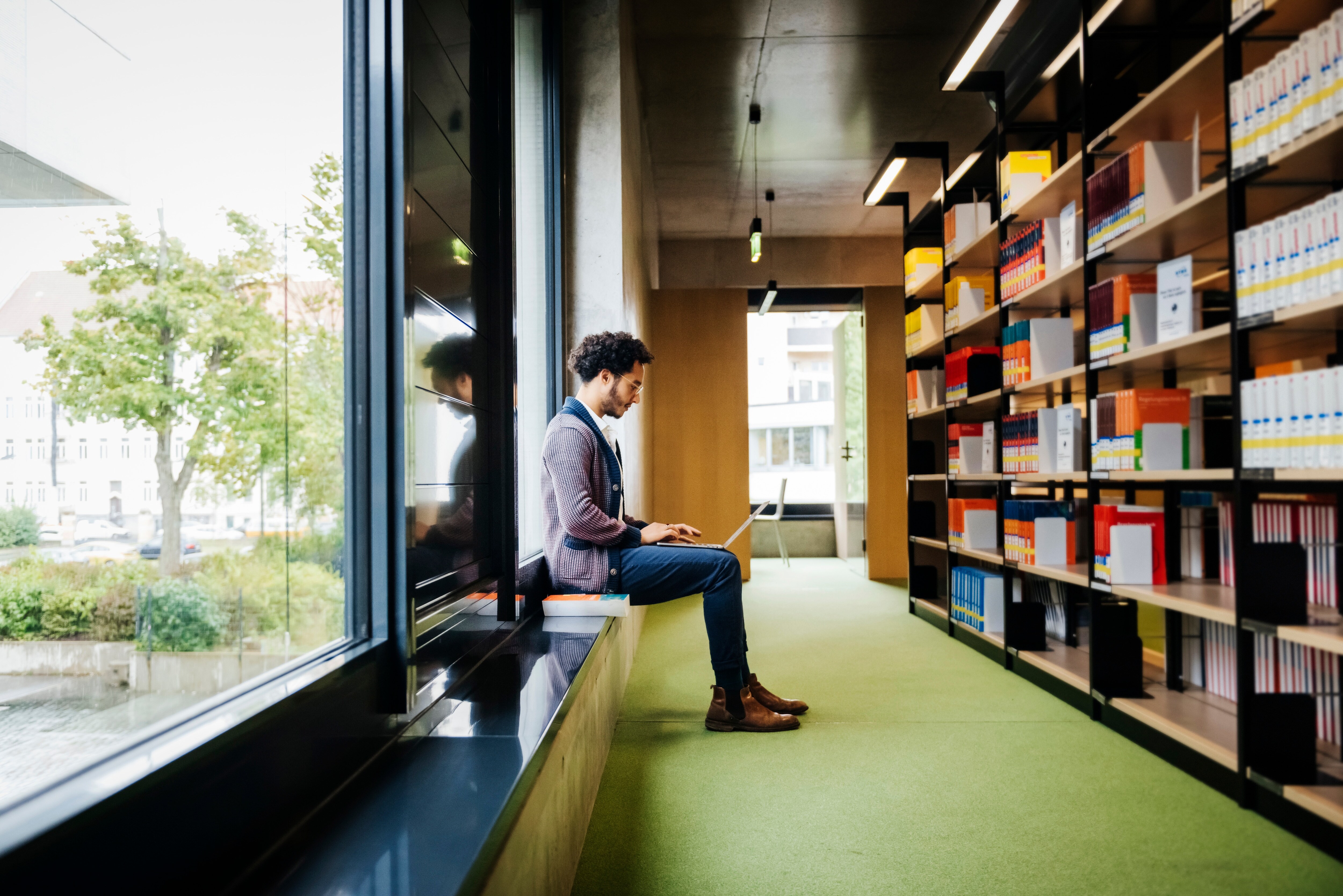 Man on laptop sitting in library