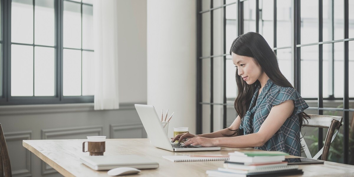 A woman working on a laptop in an office setting