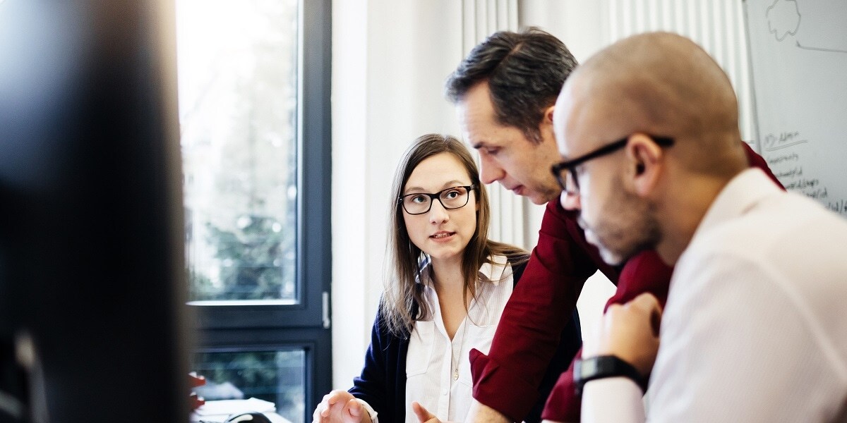 Three employees at work collaborating