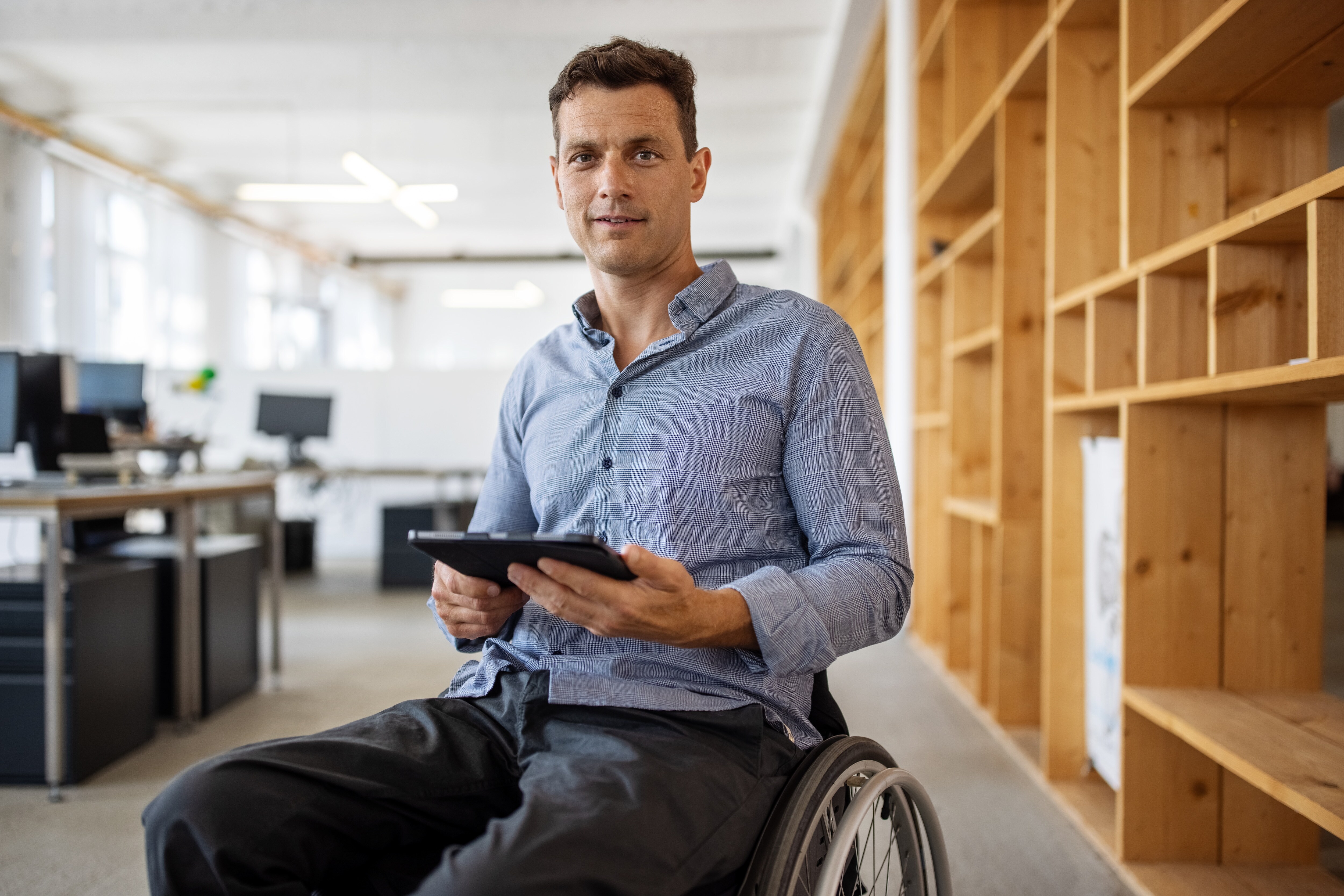 Worker in wheelchair holding tablet