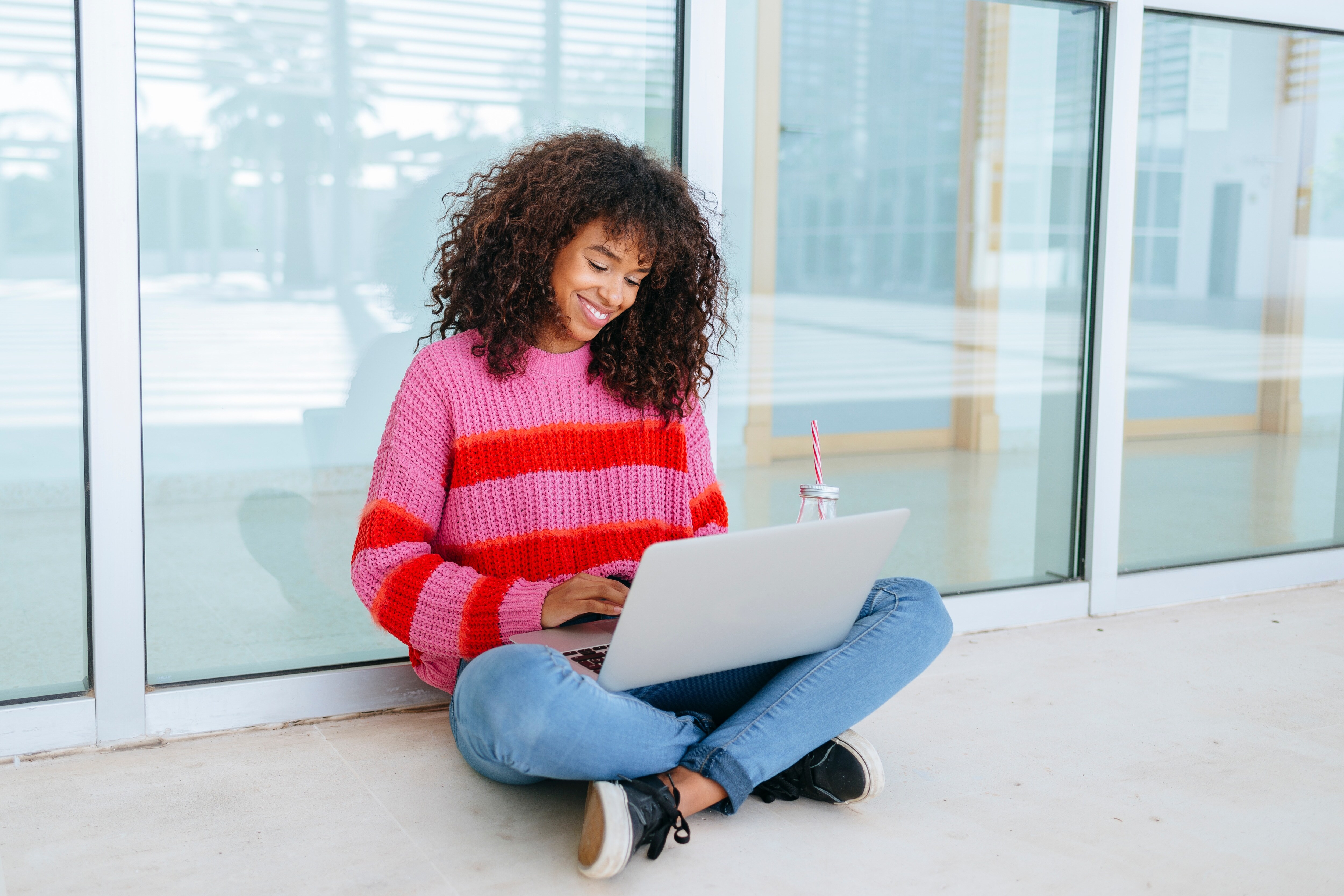 Woman sitting on the ground on her laptop