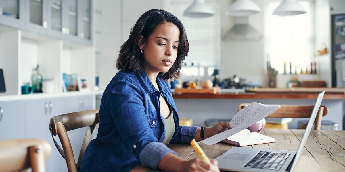 Woman working remote at home looking at a computer screen